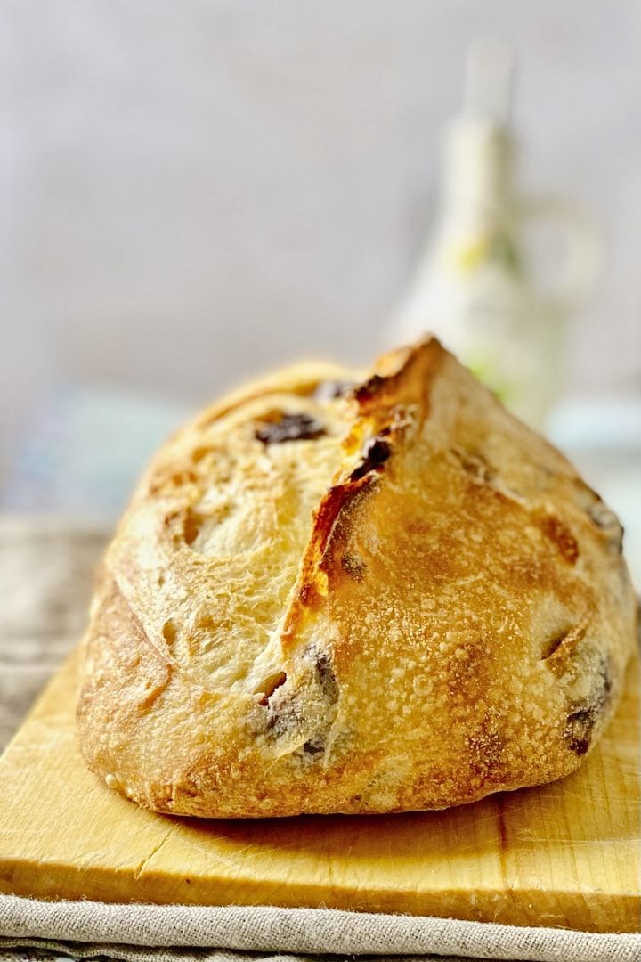 a loaf of bread sitting on top of a wooden cutting board