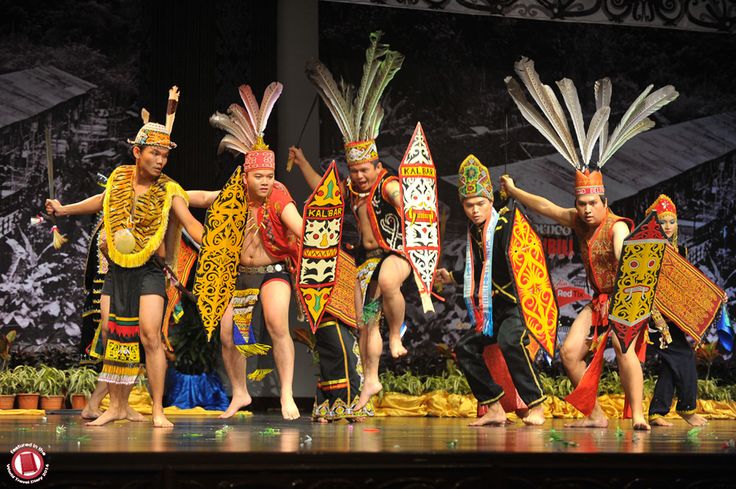 a group of people standing on top of a stage next to each other wearing costumes