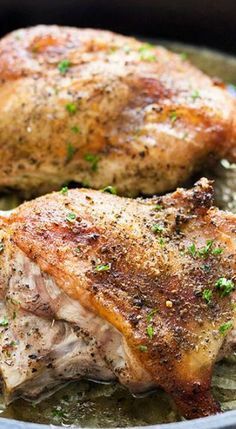 two pieces of chicken sitting on top of a pan