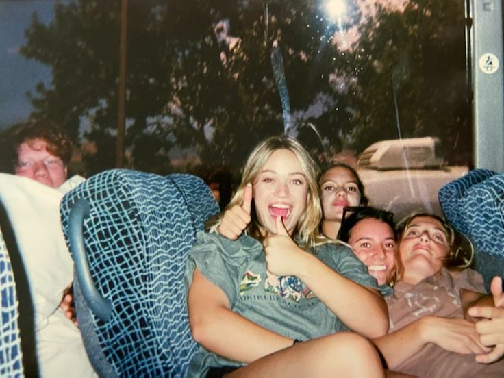 a group of people sitting on top of a blue chair