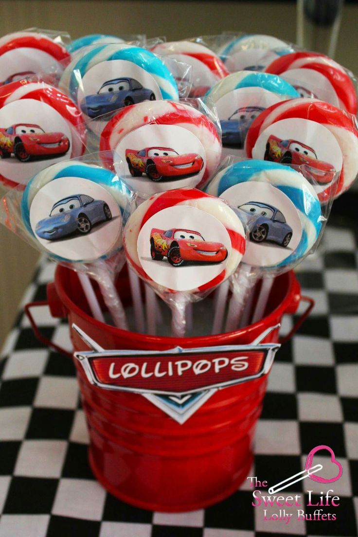 a bucket filled with lollipops sitting on top of a checkered table