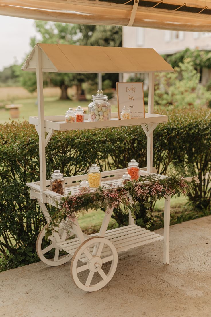 a white cart filled with lots of food on top of a lush green park area