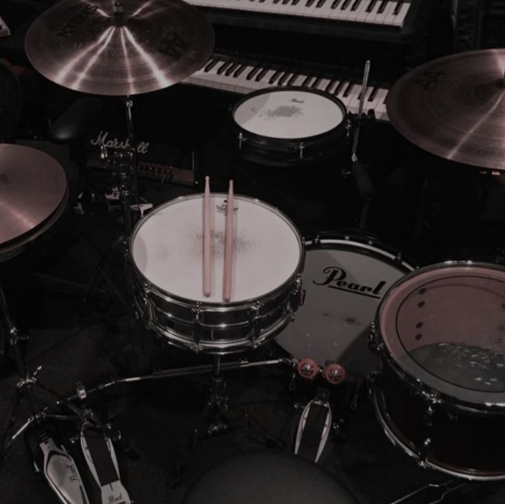 a drum set up with sticks in front of it