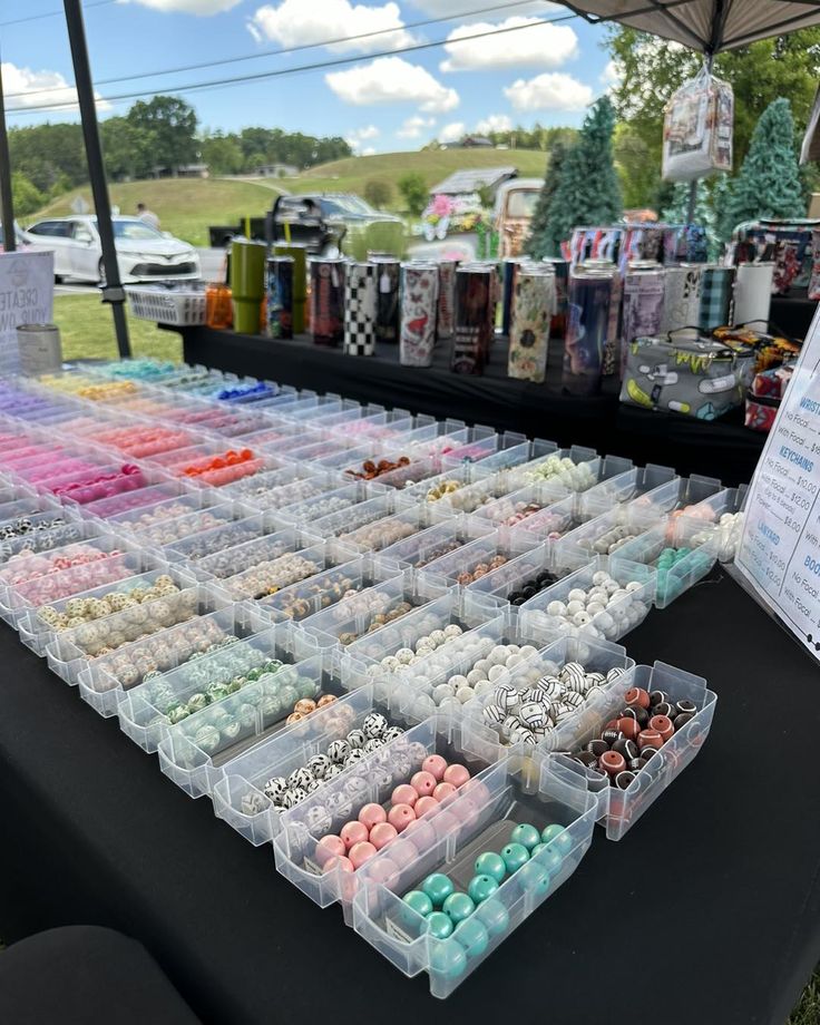 there are many different items on display at this outdoor vendor's market, including buttons and beads