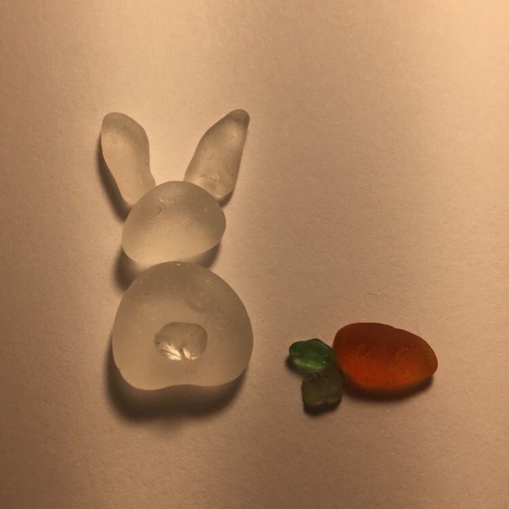 a plastic bunny and carrot on a white surface