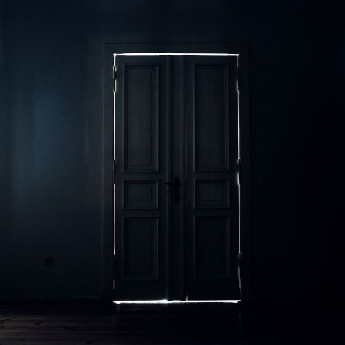 an open door in a dark room with light coming through the doorway and on the floor