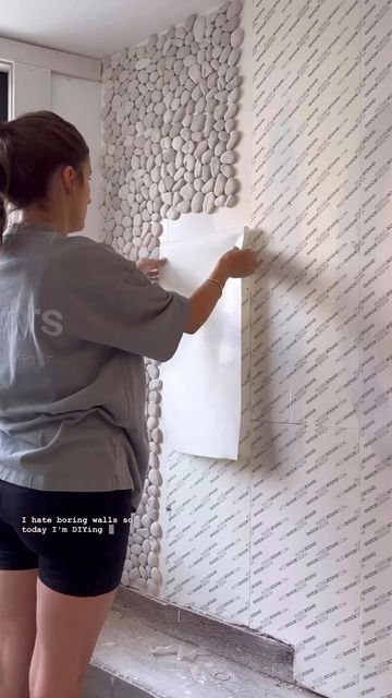 a woman is painting a wall with white paint