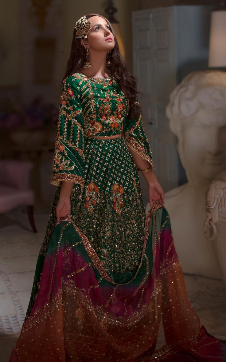 Buy Traditional Mehndi Dress that comes in Green Lehenga Choli beautifully embellished with hand-crafted adornments and embroidery work. Custom Sizes. Green Mehendi Outfits For Bride Pakistani, Bridal Mehndi Dresses Green, Lengha Choli Pakistani Mehndi, Emerald Green Mehndi Outfit, Green And Orange Mehndi Dress, Emerald Green Pakistani Dress, Colorful Mehndi Outfit, Mehndi Lehnga Pakistani Lehenga Choli, Asian Mehndi Outfits