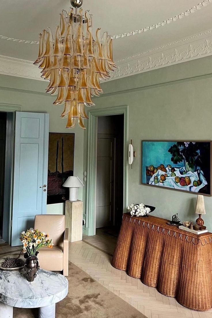 a living room filled with furniture and a chandelier hanging over the top of it