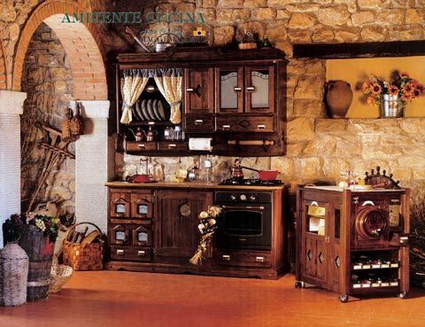 an old fashioned kitchen with stone walls and wooden cabinets in the center, along with other antique furniture