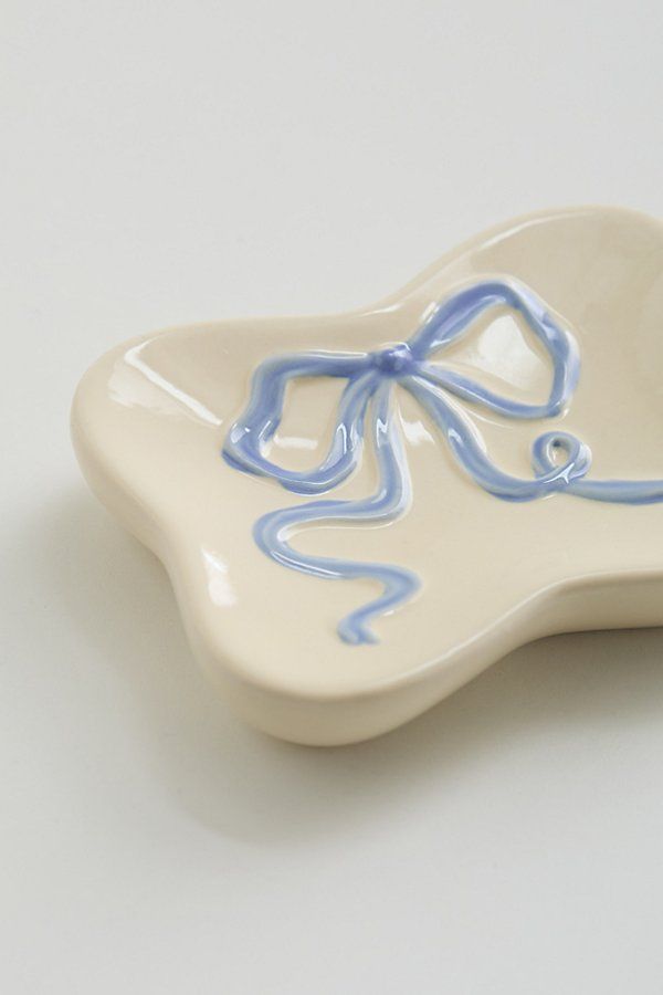 a white and blue dish with a bow on it