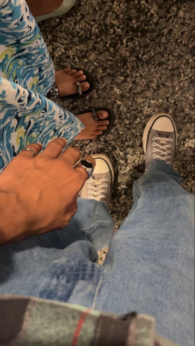 two people sitting on the ground with their feet crossed