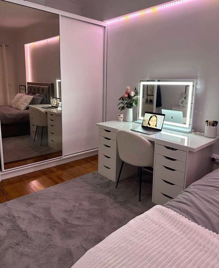 a bedroom with a bed, desk and mirror