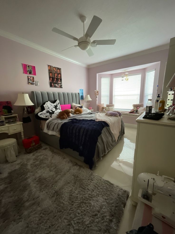 a bed room with a neatly made bed and a ceiling fan