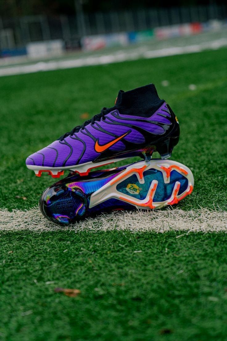 a pair of purple and orange soccer cleats on the field