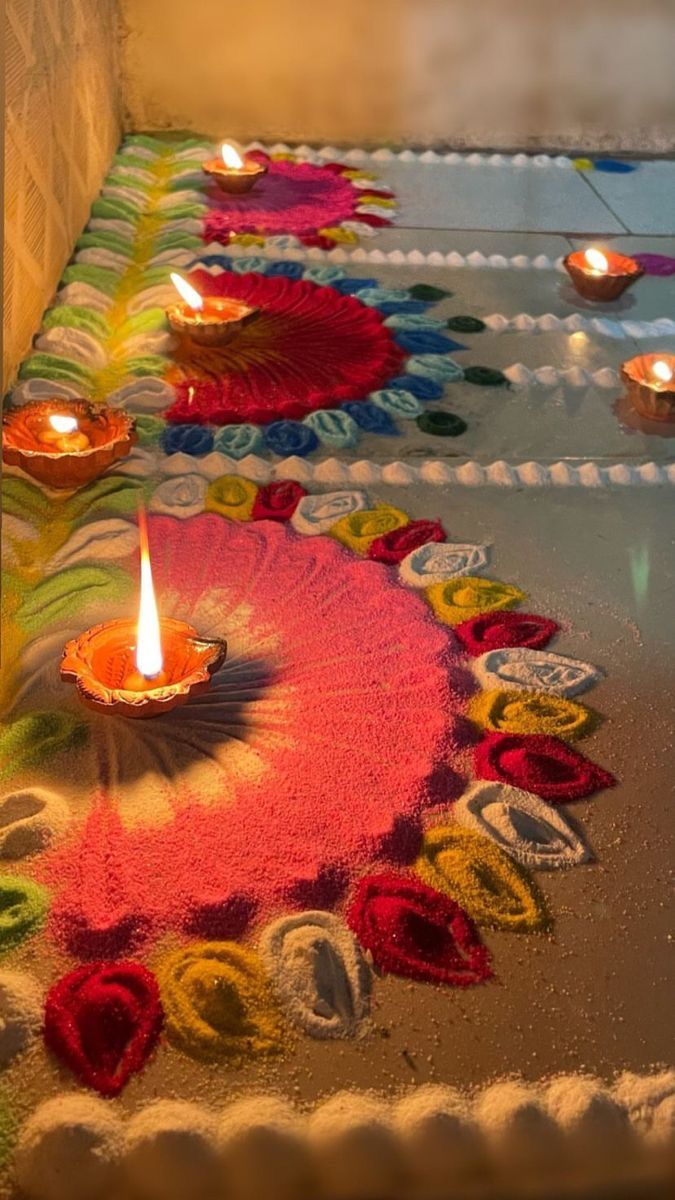 candles are lit on the ground with colorful designs