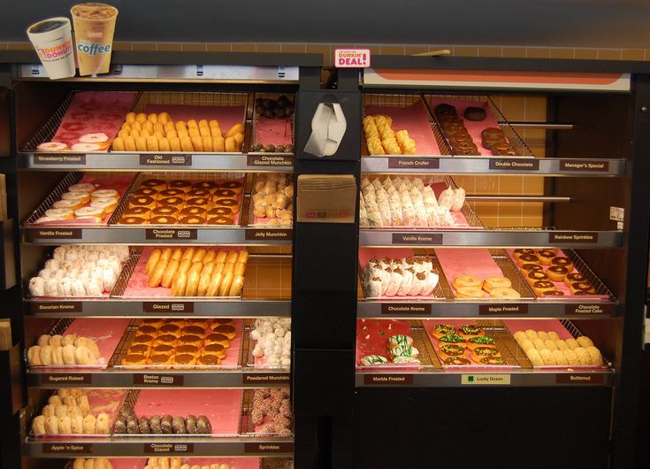 a display case filled with lots of different kinds of doughnuts and pastries