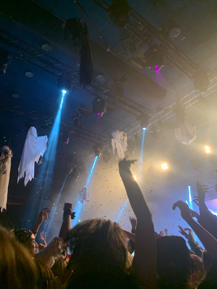 a group of people standing on top of a stage with their hands in the air