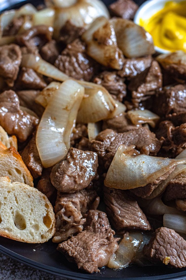 meat and onions on a plate with bread