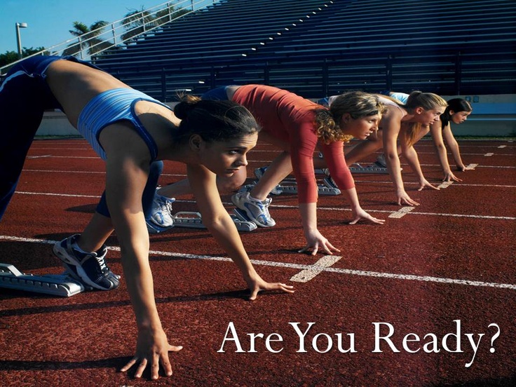 three women are lined up on the starting line to start a race in a stadium