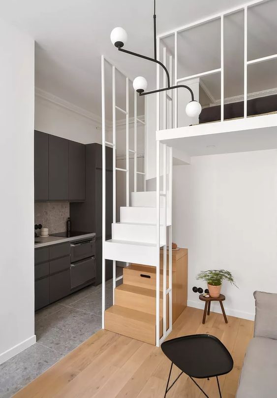 a living room filled with furniture next to a white stair case and wooden flooring