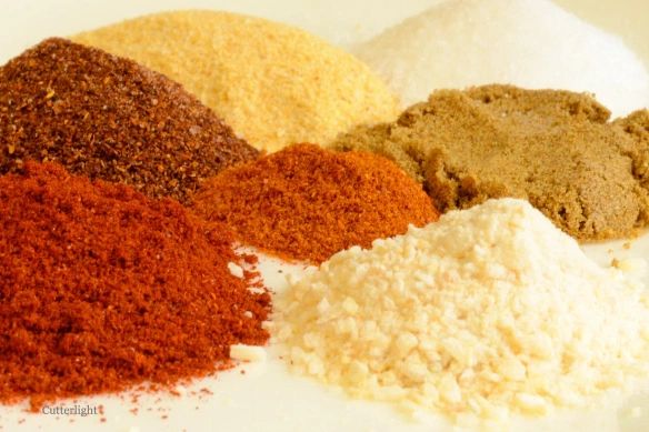 several different types of spices on a white plate