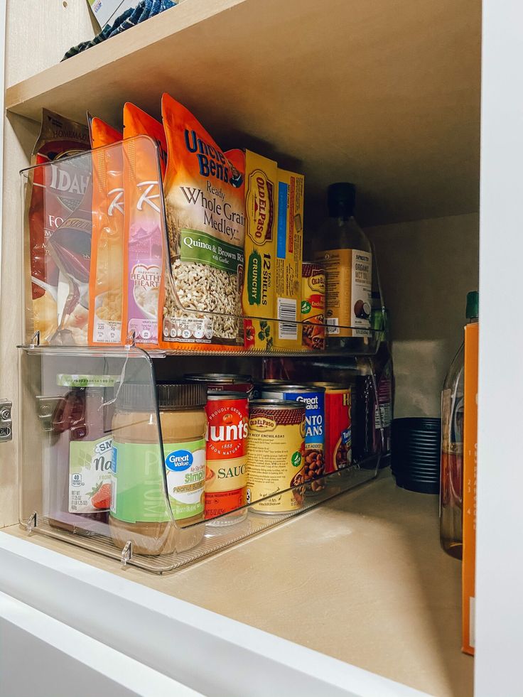 a pantry shelf filled with lots of food and condiments on top of it