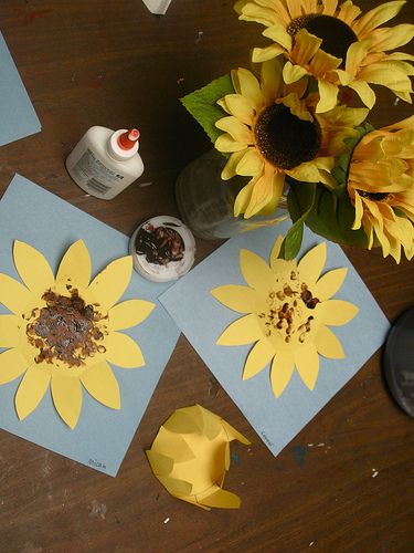 sunflowers and other crafting supplies laid out on a table with paper flowers