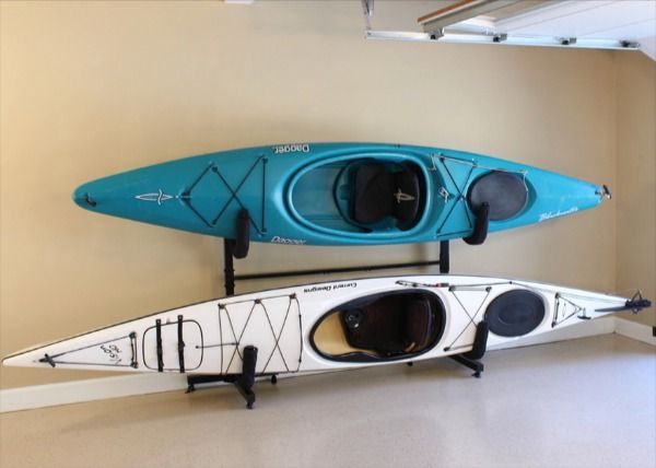 two blue and white kayaks sitting next to each other in a room with an open door