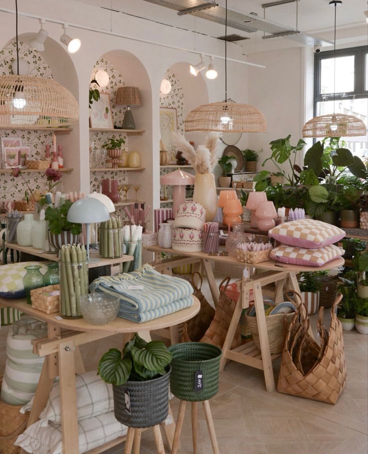 a room filled with lots of different types of pillows and baskets on the floor next to plants