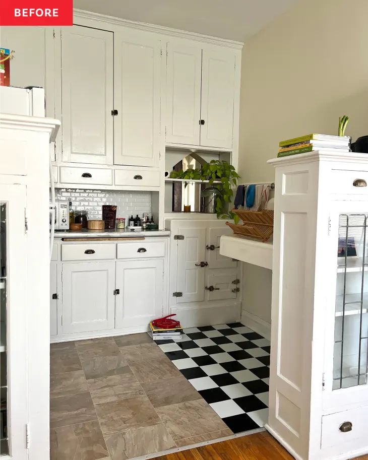 a kitchen with white cabinets and black and white checkered flooring on the tile