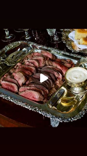 an image of meat and bread in a tray on a table with other food items