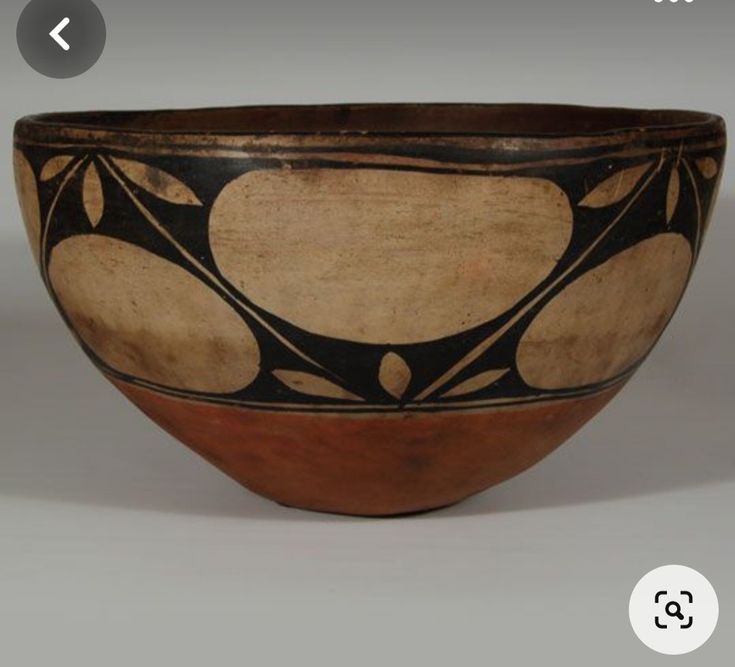 a brown and black bowl sitting on top of a table