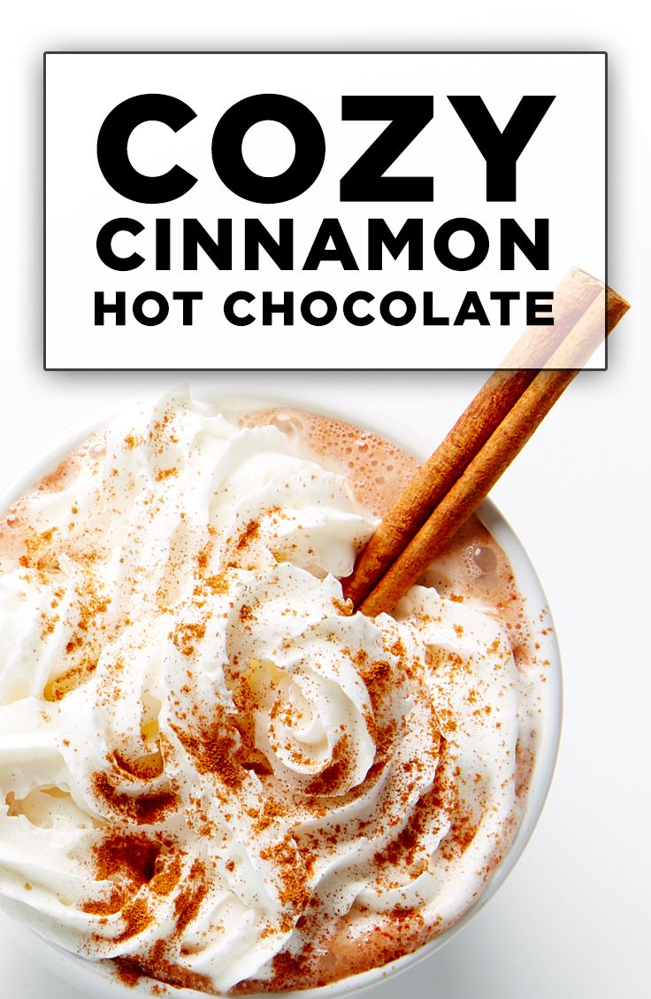 a cup of hot chocolate with whipped cream and cinnamon sticks in it next to a sign that says cozy cinnamon hot chocolate