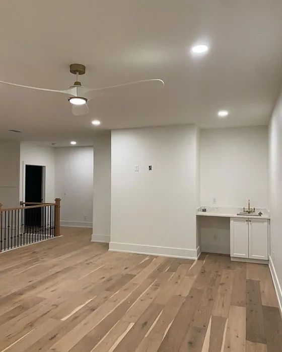 an empty room with hard wood floors and white walls