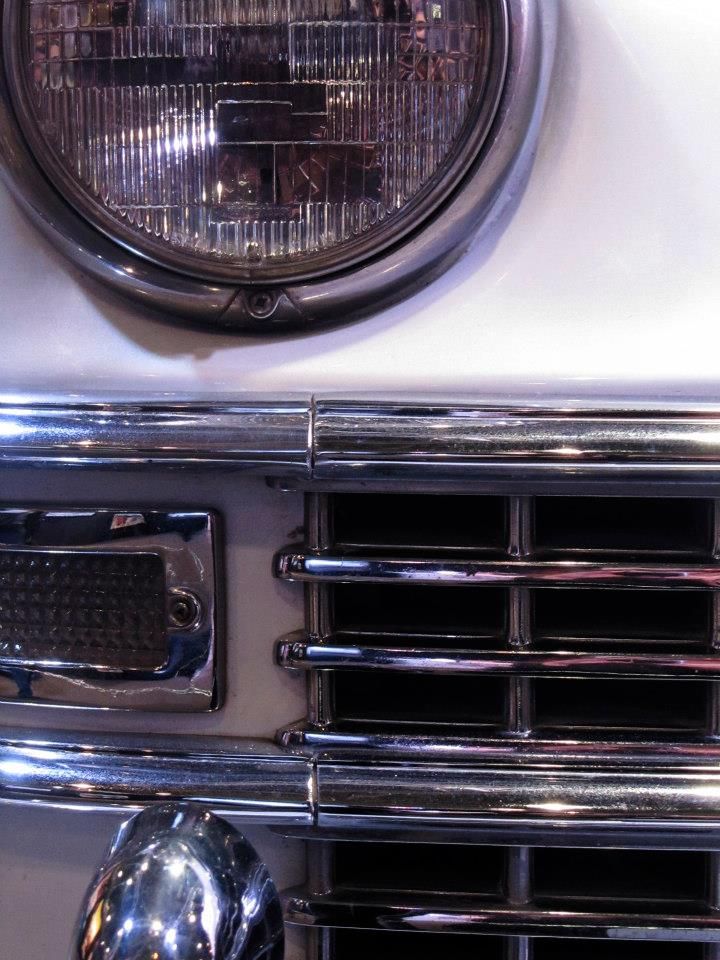 the front end of an old car with chrome grilles and lights on it's headlight