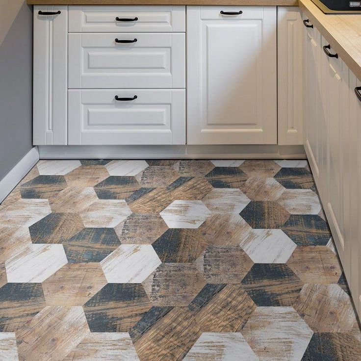 a kitchen with white cabinets and wood flooring on the counter top, along with an area rug that looks like hexagonal tiles