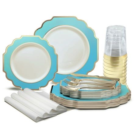 a blue and white dinner set with gold rimmed plates, silverware and napkins