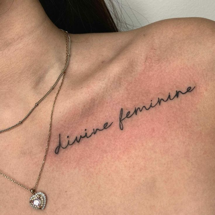 a woman's chest with the words divine feminine written on it and a diamond necklace