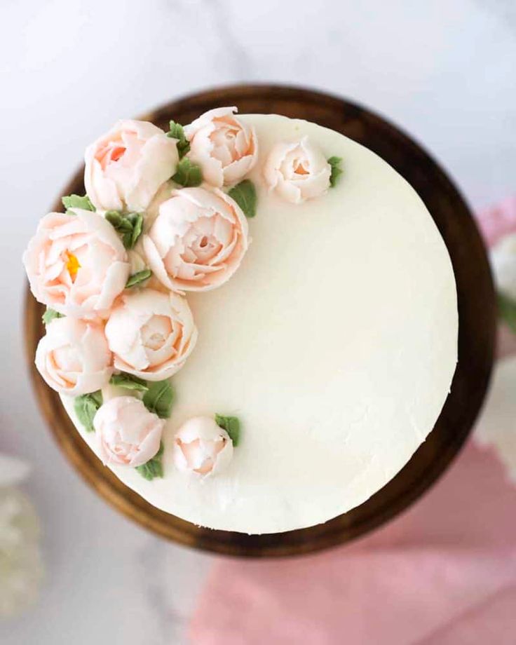 a cake with white frosting and pink flowers on top