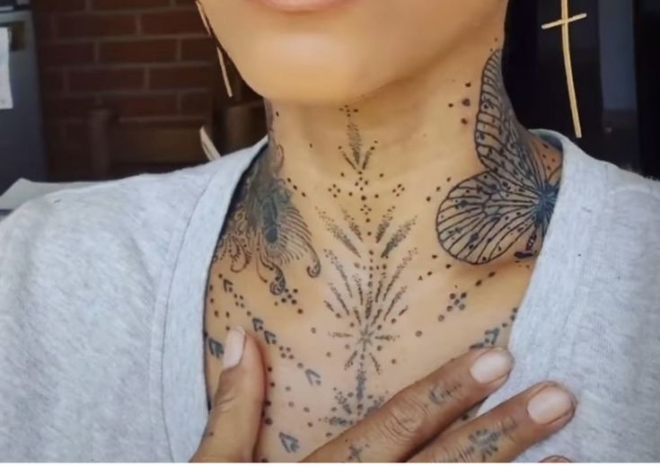 a woman with butterfly tattoos on her chest and chest is looking up at the camera