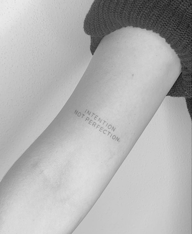 a woman's arm with the word intention written on it, in black and white