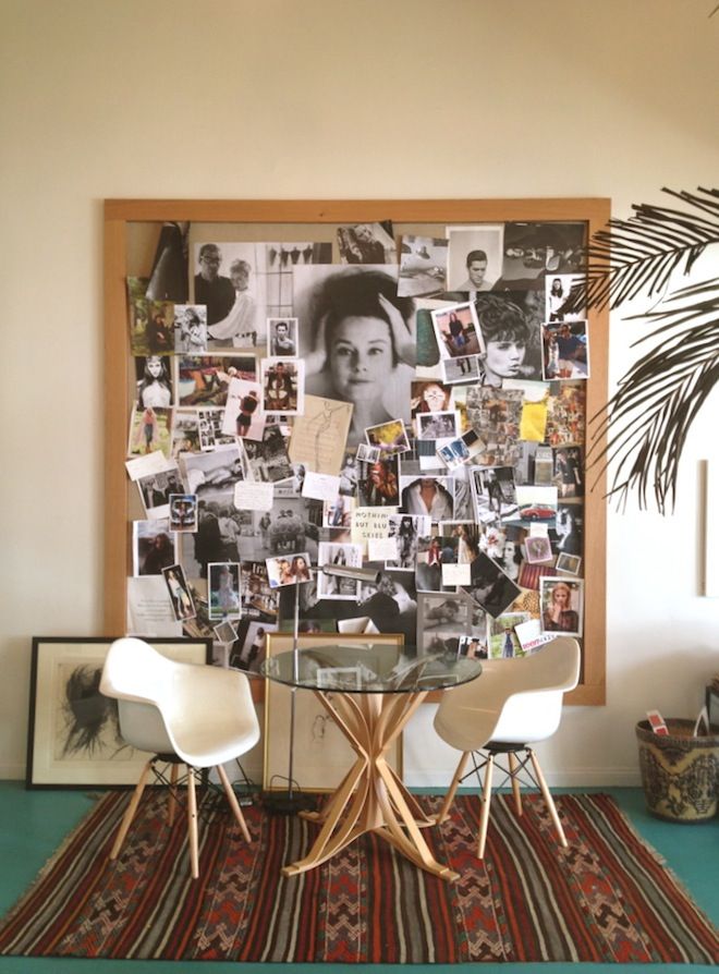 there is a table with chairs and pictures on the wall behind it in front of a potted plant