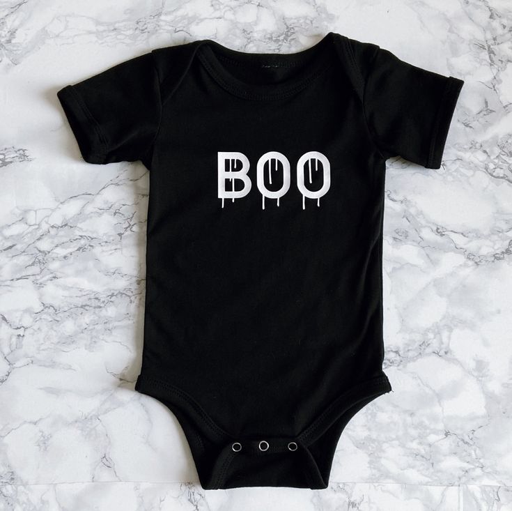 Nothing too spooky about this adorable Halloween onesie, perfect for your October babe. Matches the adult "Bad & Boozy" T-shirt. Comes in Black or White. Recommended Care Instructions Machine wash delicate cycle, cold/warm, inside out with like colors. Remove immediately after washing. Tumble dry on low or hang dry. Do not iron decal. Do not dry clean. Funny Fitted Black Onesie, Fun Black Cotton Onesie, Black Cotton Halloween Onesie, Cute Black Cotton Bodysuit, Playful Fitted Black Onesie, Black Fitted Playful Onesie, White Halloween Onesie In Casual Style, Casual White Onesie For Halloween, White Casual Onesie For Halloween