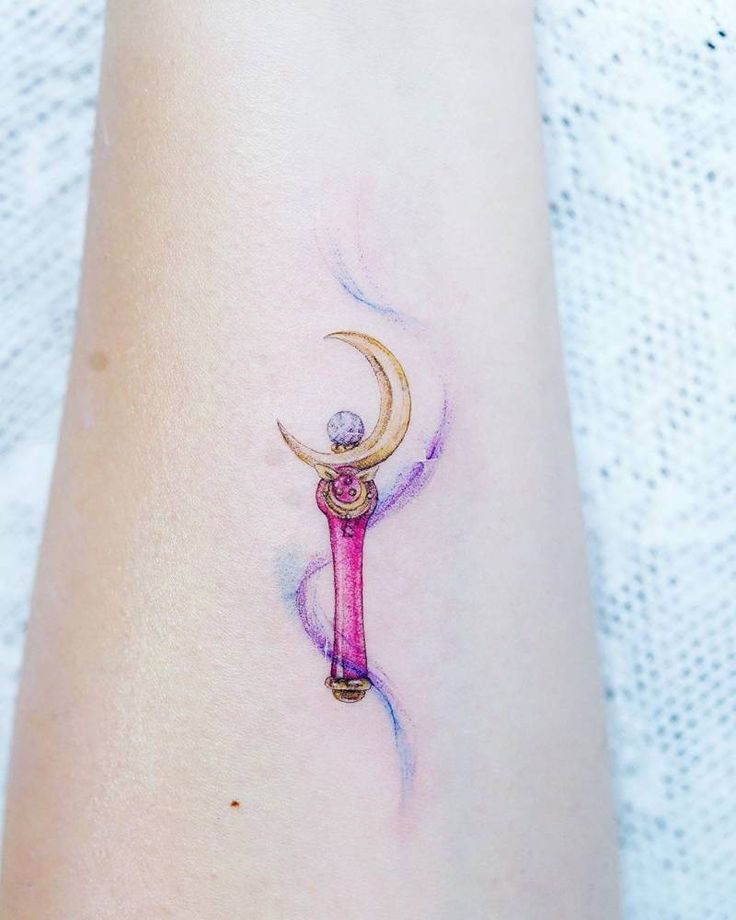 a woman's arm with a tattoo on it that has a crescent moon and a pink umbrella