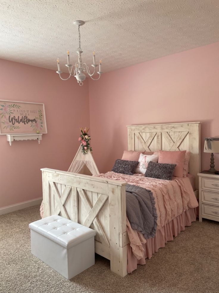 a bed room with a neatly made bed and a chandelier hanging from the ceiling