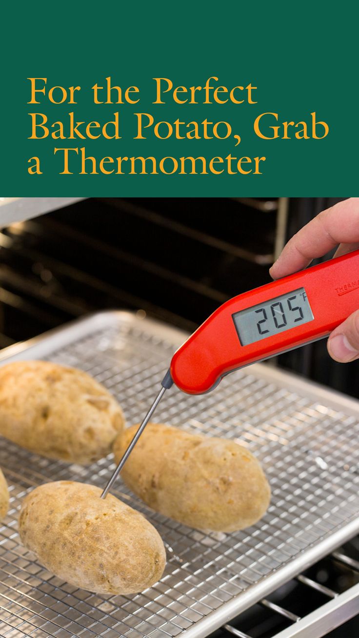 a person using a thermometer to measure baked potatoes