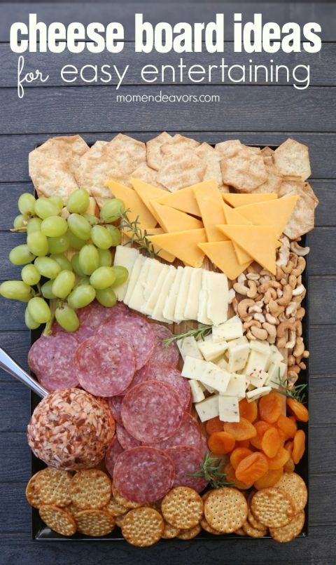 an assortment of cheeses, crackers, and meats on a platter