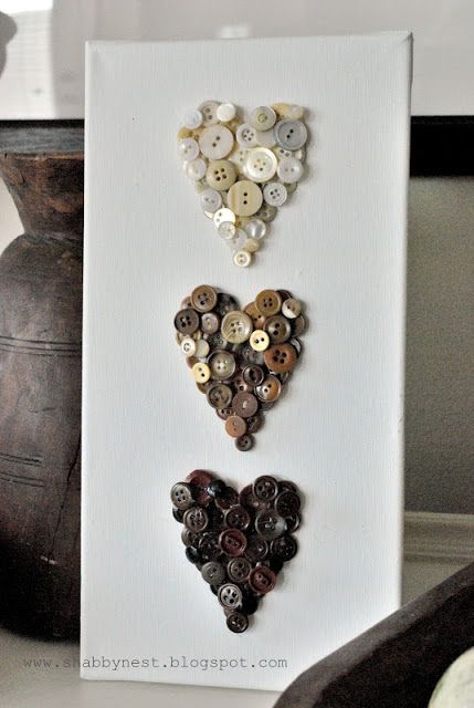 three buttons in the shape of a heart on a white board next to a potted plant