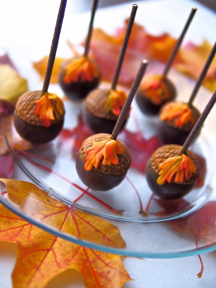 chocolate candies with orange flowers and leaves on a glass platter, ready to be eaten